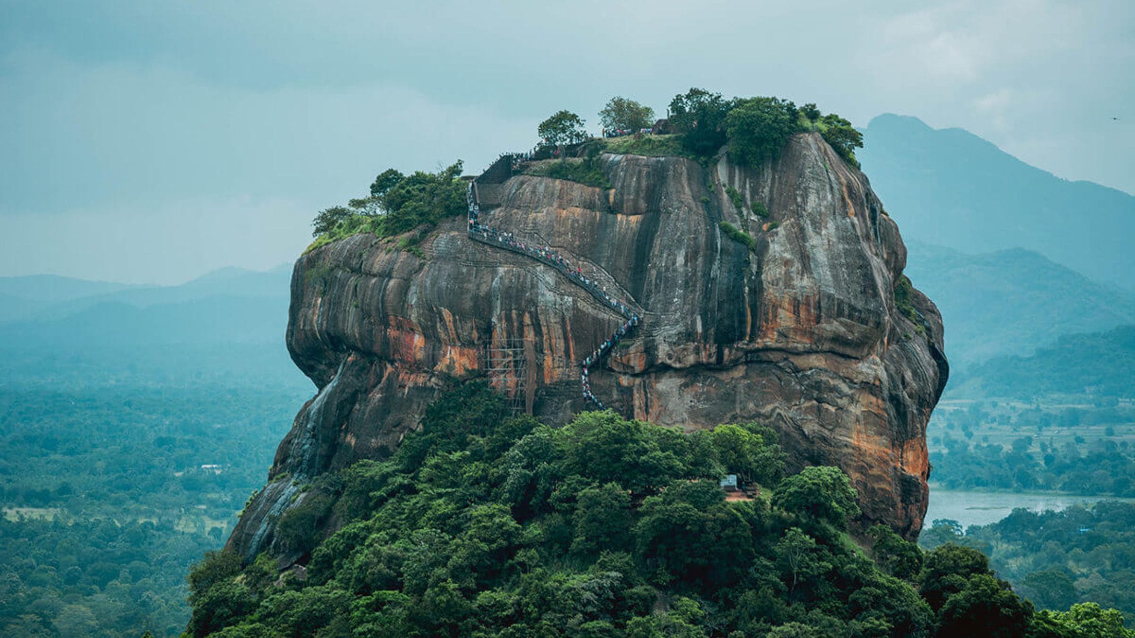 Sigiriya Rock fortress rising from lush greenery.