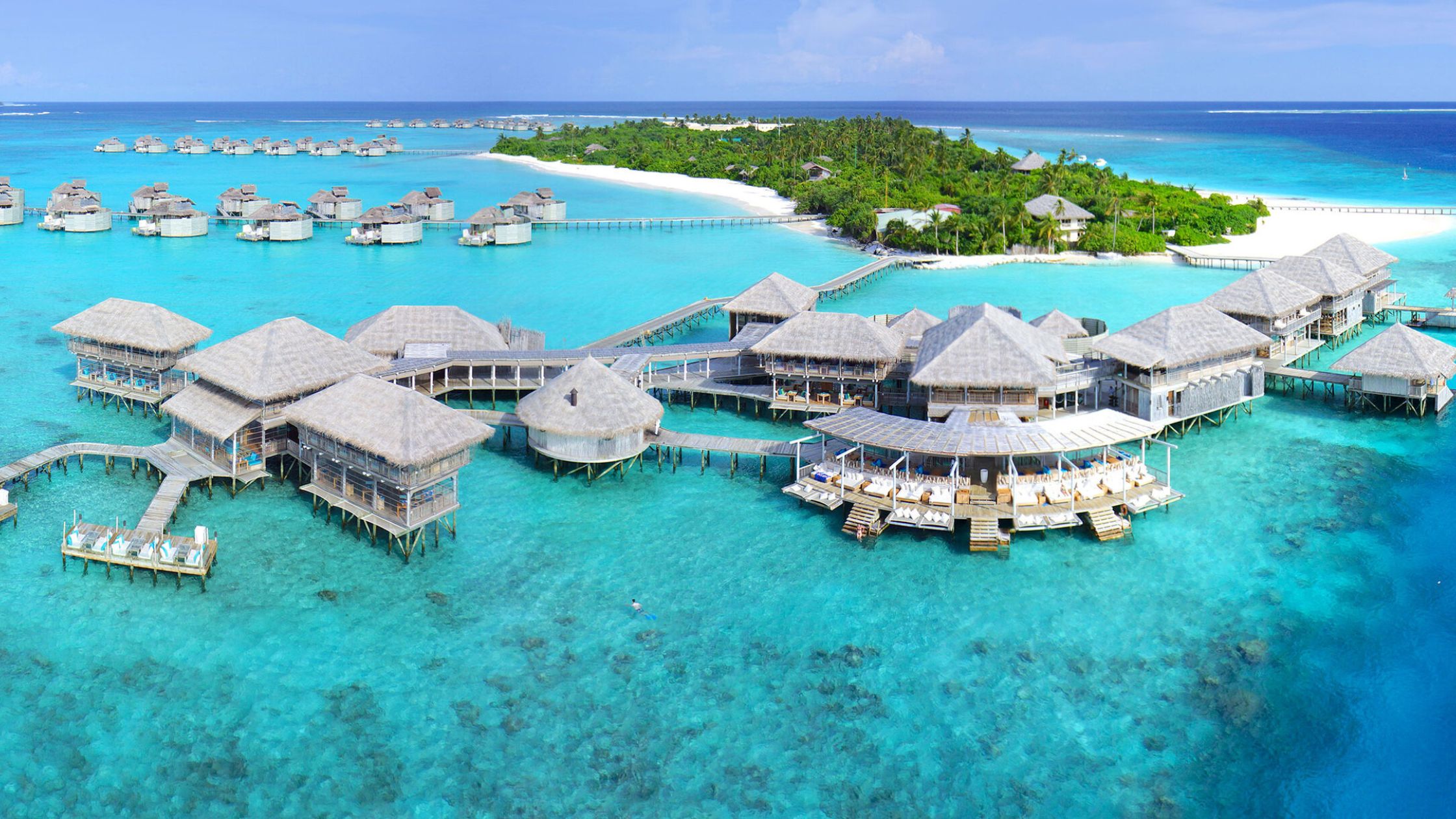 Maldives beach with overwater villas and clear blue water